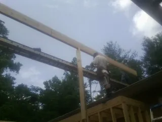 Carpenter setting a ridge beam over a new addition frame — Ice Dam Removal by Roofing Brothers in Flandreau