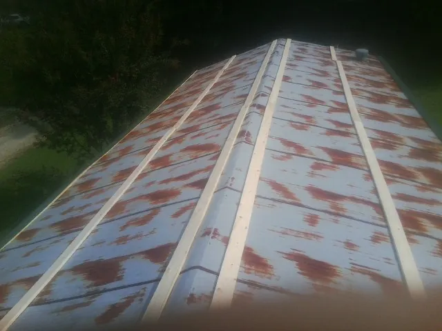 Rusted metal roof panels with new wood purlins before replacement — Storm Damage Roof Repair in Flandreau by Roofing Brothers